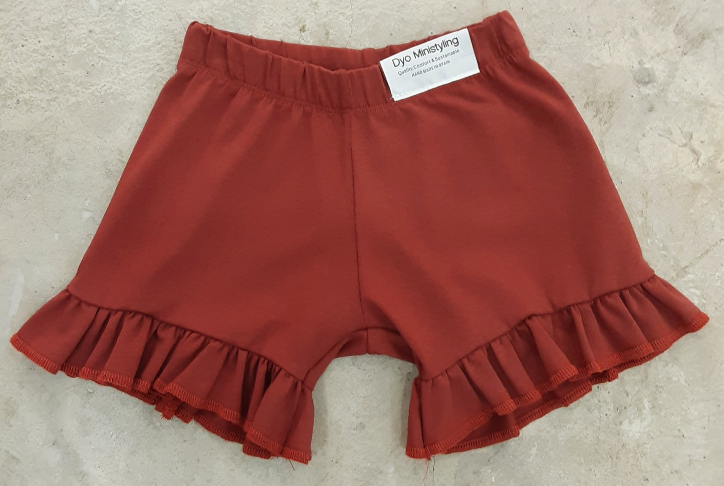 PANTALON CORTO COLOR TEJA VOLANTES