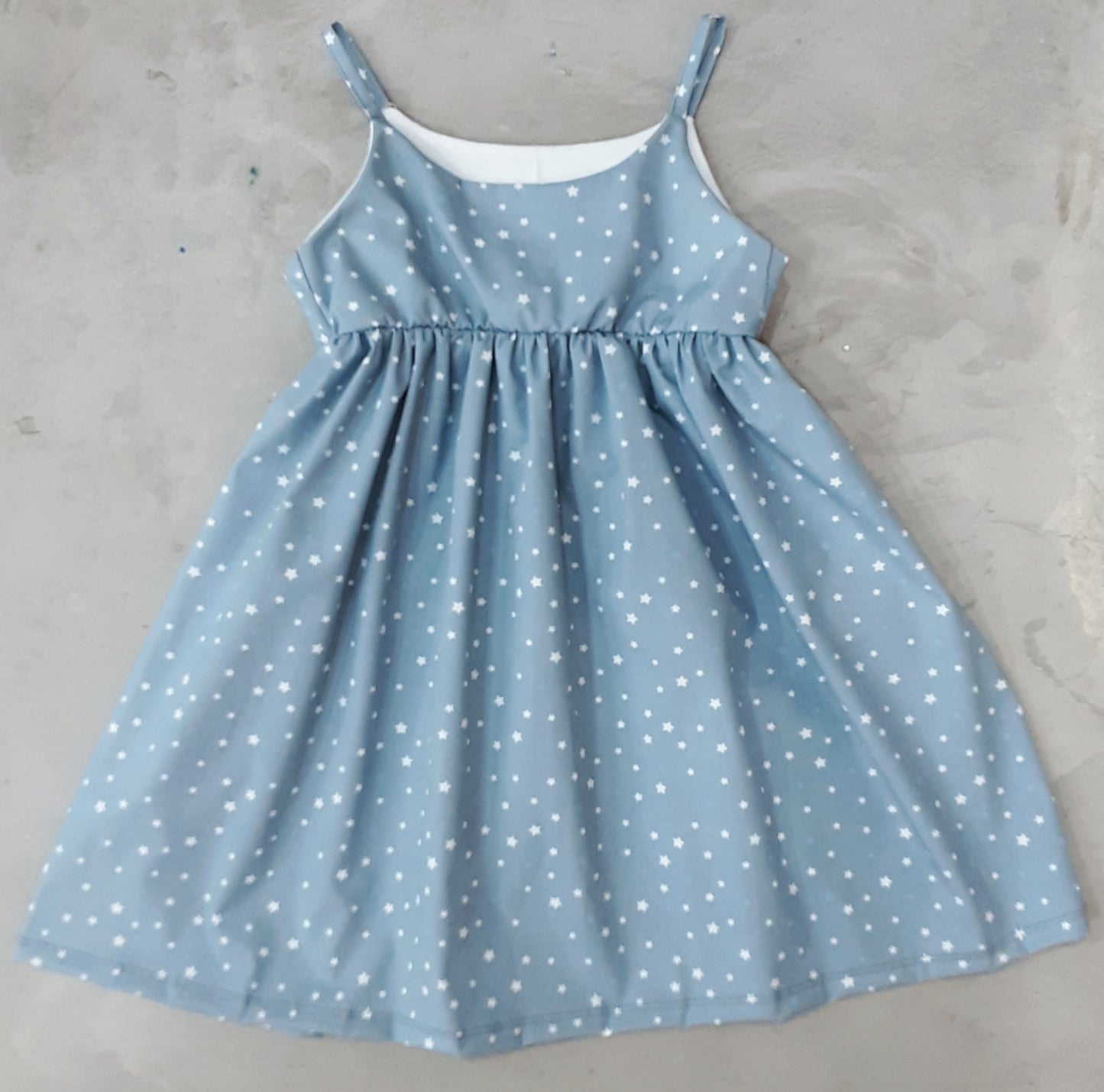 VESTIDO NIÑA AZUL CLARITO ESTRELLAS BLANCAS .